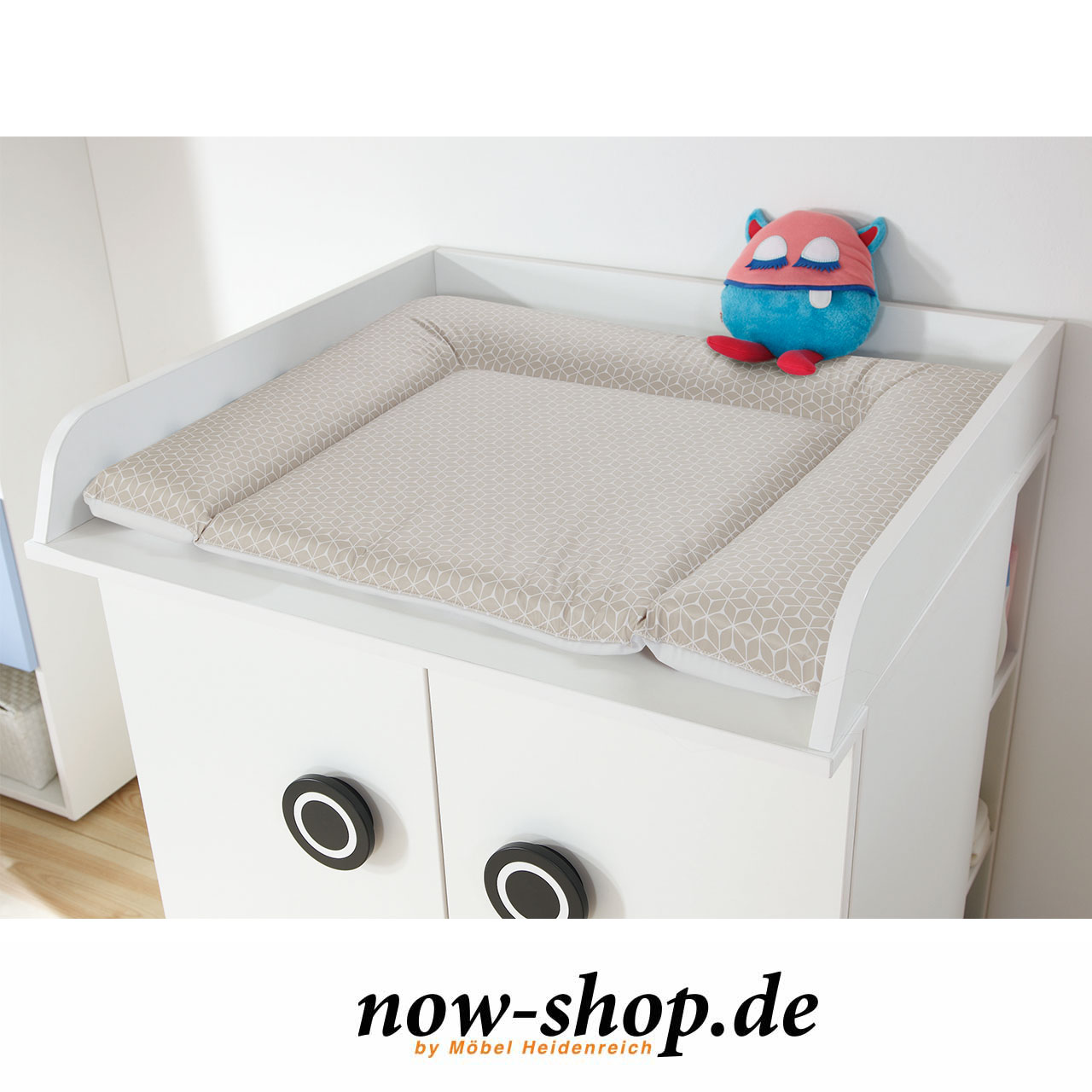Wickelauflage mit taupefarbenen Rauten auf Wickelaufsatz auf Kommode. Wickelaufsatz mit Wickelauflage auf Kommode mit Unterstellregal