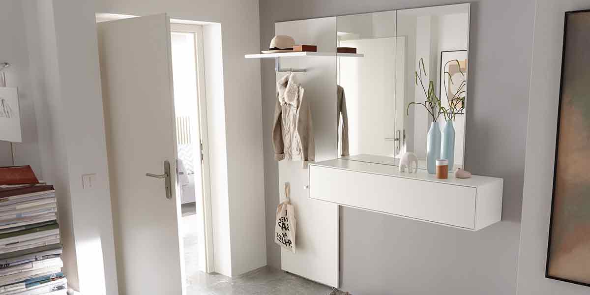 Titelbild Garderobe Milieubild einer Garderobe bestehend aus dem weißen Garderobenpaneel mit Hutablage und einem Hängeelement mit Spiegel. Alles in weiß.