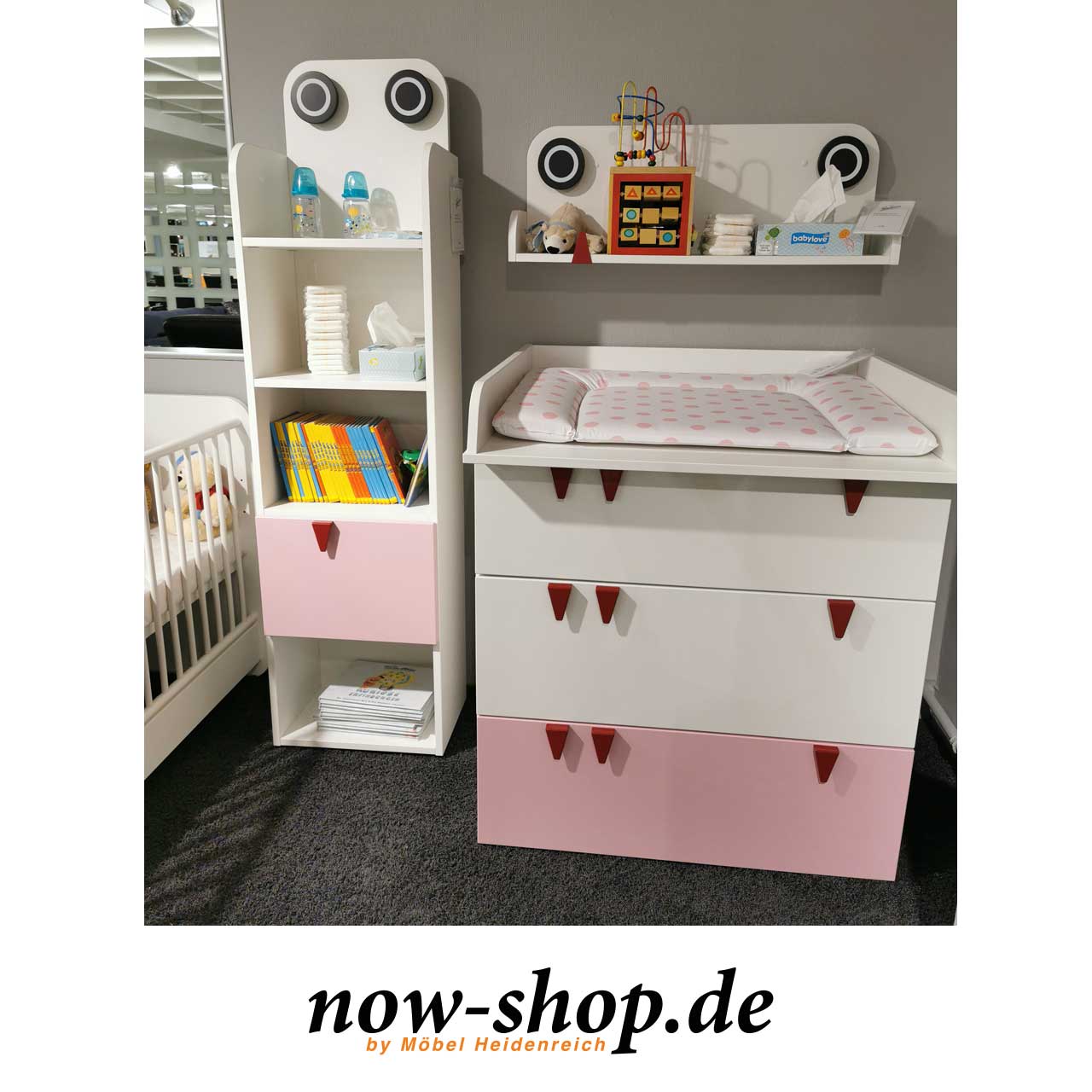 now! by hülsta – minimo Regal mit rosa Akzent Ausstellungstück Milieu Milieuaufnahme des Artikels im Möbelhaus kombiniert mit Wickelkommode und Wandbord.